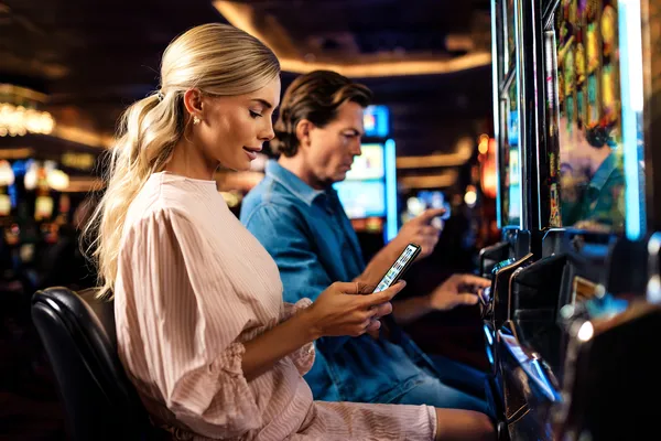 A cheerful woman in traditional clothing using her smartphone during a festive moment, showing how easily the JLWILD app fits into everyday life.