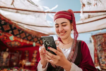 A player using their smartphone during a festive local event, representing JLWILD’s fully mobile-friendly casino.