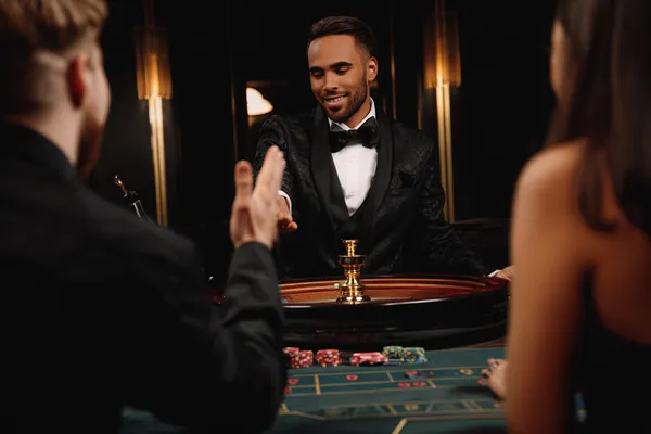 A confident dealer surrounded by casino chips inviting players to access their JLWILD account, reflecting quick and easy login options.